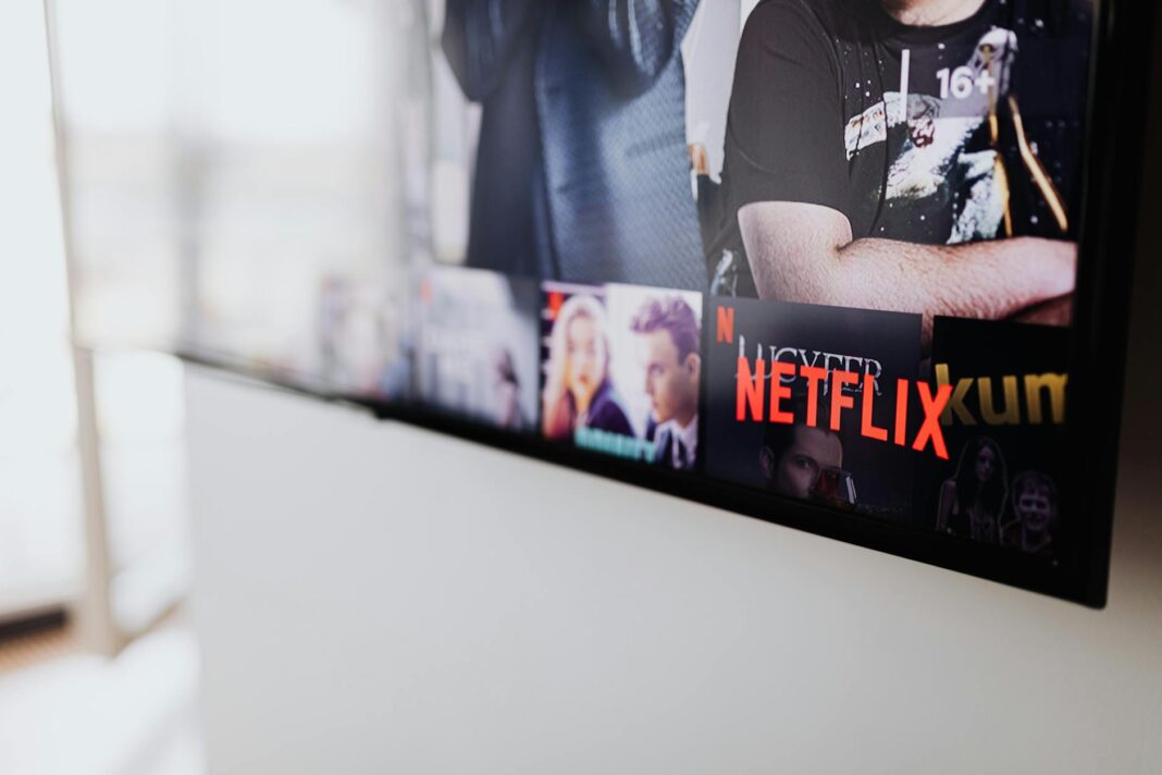 Person relaxing watching a movie on a laptop.